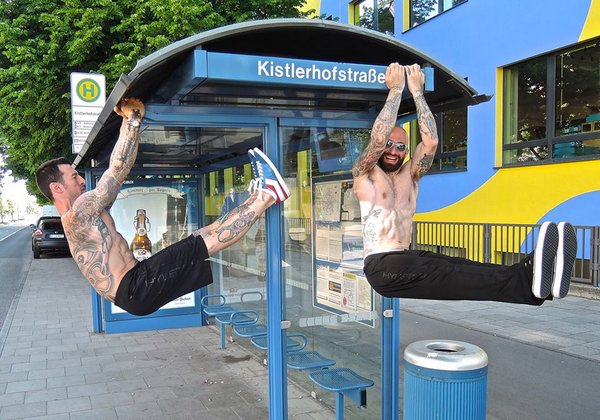 Al and Danny Kavadlo demonstrate hanging L-Sits at a bus stop in Munich, Germany